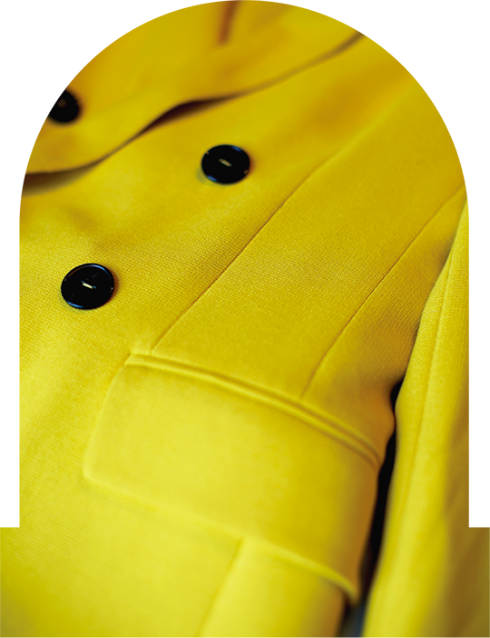 Manufacturing yellow double breasted blazer laying on table with customized buttons