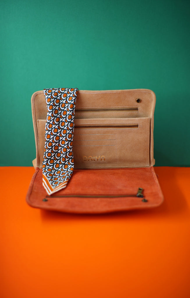 rust and sand taupe clutch with three zipper and snap closure draped in silk scarf