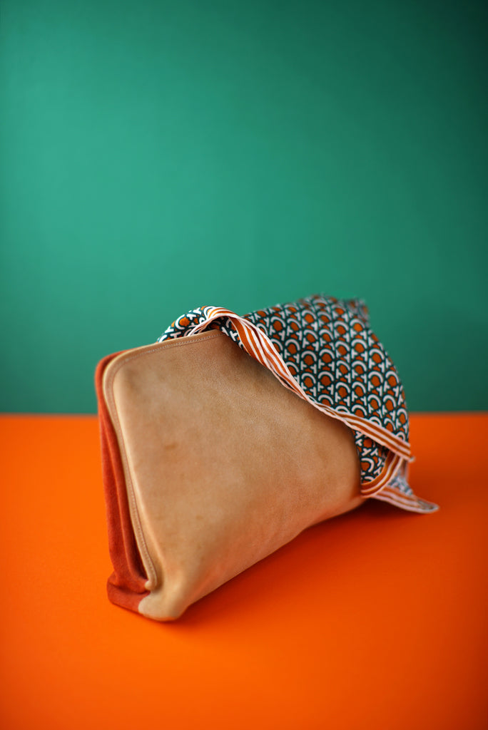 sand suede and rust clutch draped in silk scarf